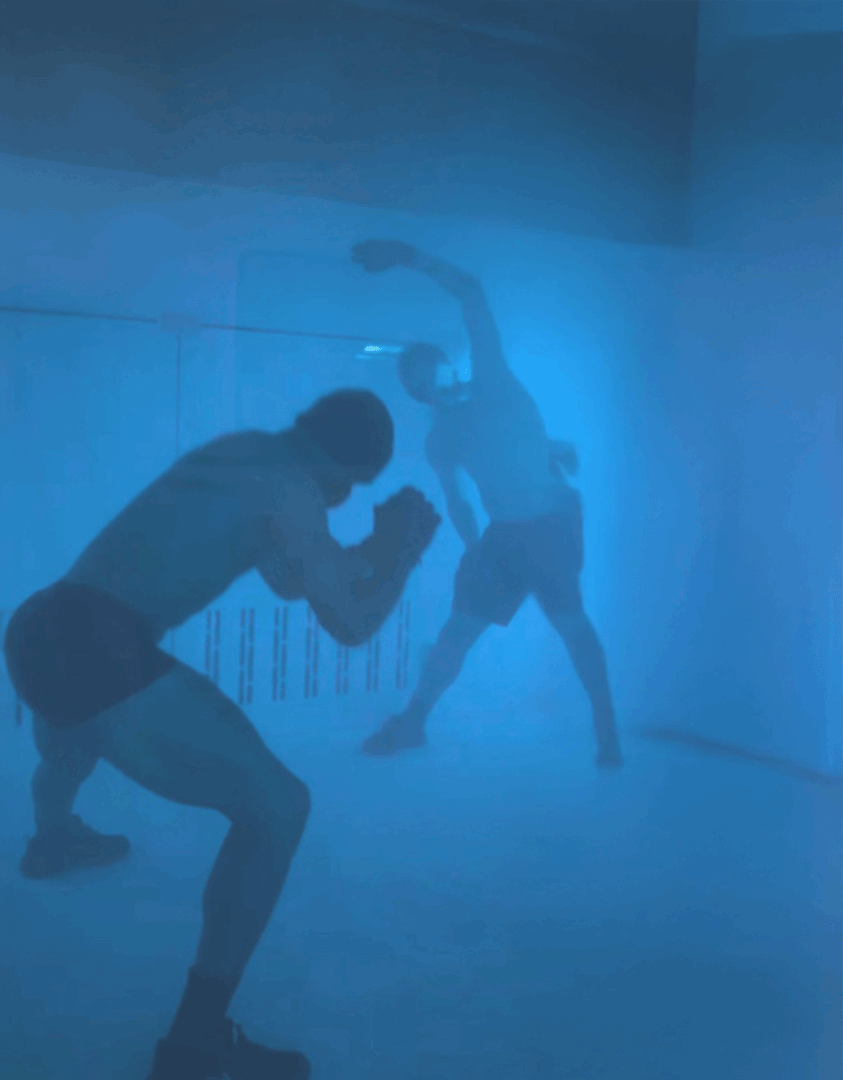 Two people training together in a lit recovery room