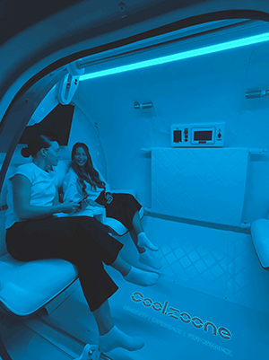 Two friends inside a longevity recovery pod
